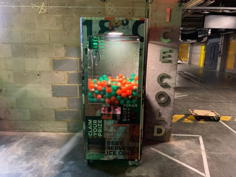 Vinyl-wrapped Jagermeister claw machine filled with orange, green and gold balls at the venue