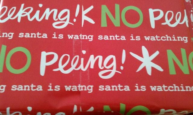 Red No Peeking wrapping paper with the printed words cut off at the joins